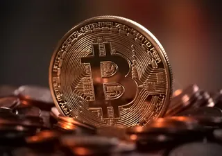 A physical Bitcoin souvenir coin among other coins
